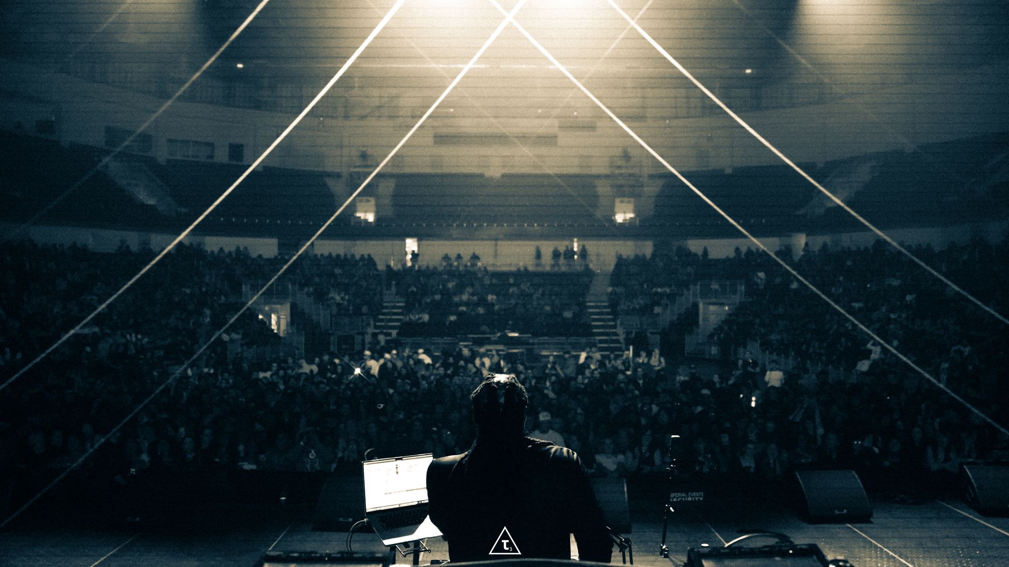 DJ Sole at the decks facing a packed arena crowd